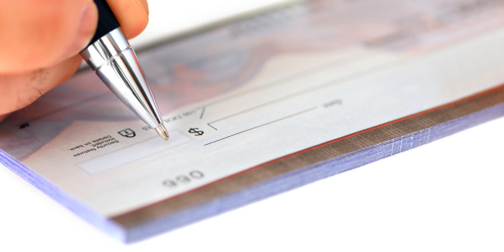 Closeup of person's hand writing a check