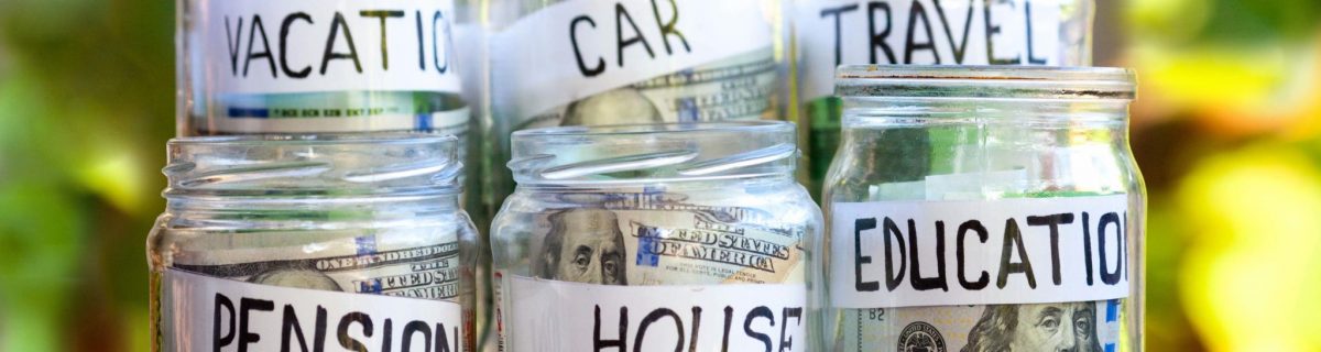 Money jars with money in each with tags that read vacation, car, travel, pension, house and education.